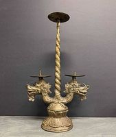 Front view of brass double dragon candle holder showing full structure and top plate