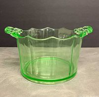 Front view of green uranium glass ice bucket showing octagonal body and both decorative handles
