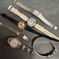 All six watches laid out showing variety of cases and straps