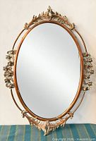 Front view showing full oval mirror and ornate copper/brass frame