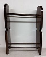 Front view of wooden quilt rack showing overall structure with two dowel bars