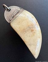 Front view of curved milky moonstone pendant with partial coin cap and jump ring