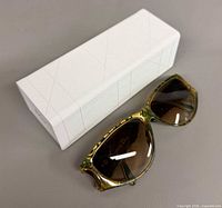 Sunglasses next to white Dior case