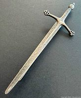 Front view of sword-shaped silver kilt pin brooch