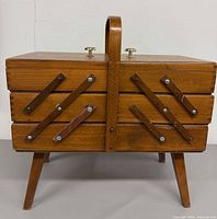 Front view of wooden accordion sewing box closed