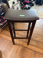 Front/angled view of one chair displaying wood frame and vinyl seat