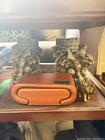 Two gargoyle bookends with wood box and brass elephant on shelf
