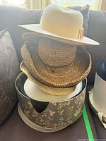 Stack of assorted hats on floral hat box