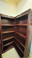 full view of interior and shelves of both bookshelves positioned at right angle