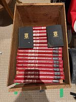 Crate containing 18 hardcover volumes, 16 red and 2 black