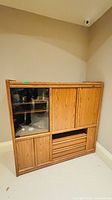 Front view of oak cabinet showing glass door, wood doors, drawers