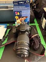 Canon EOS DSLR with 75-300 mm lens, strap, pouch, Epson PictureMate 200 Series Print Pack box