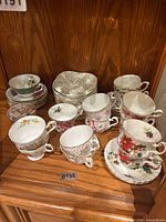 Overview of teacups and saucers showing quantity and mixed patterns
