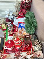 Overview of lot with cookbook, ceramic items, trays, artificial greenery, metal reindeer