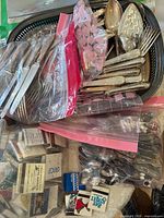 Overview of flatware pieces in bags, serving bowls, matchbooks