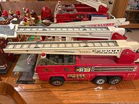 Two Tonka Hook & Ladder trucks side by side showing ladders, decals, overall condition