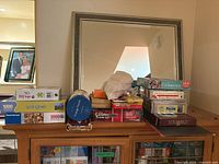 Full view of stacked games and puzzles on cabinet