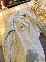 Grey Tommy Hilfiger V-neck sweater laid flat