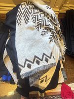 Grey and white geometric knit pullover draped over stack