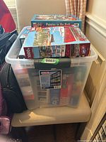 Overall view of plastic bin with puzzles stacked on top