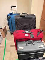 Group view of four suitcases showing colors and general condition