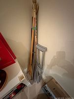 Group of paddles, ski, crutches and pole leaning against wall