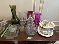 Group shot of vases, glassware, ceramic dishes stacked on sideboard