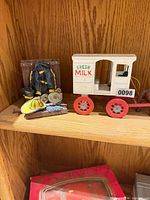 Ceramic fireman decor and milk wagon toy on shelf