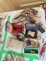 Overall view of lot showing replica pistols, boxed lighter, medals, lighters and accessories within green-taped area
