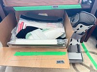 Cardboard box with medical supplies and boot visible