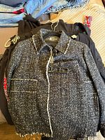 Front view of Luisa Cerano black-white tweed dress stacked with other garments