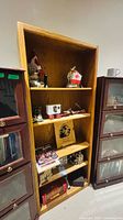 Front view of open oak-grain cabinet showing four shelves