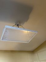 Single rectangular LED panel light hanging from ceiling by two short chains