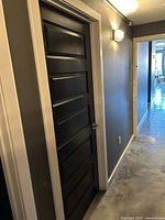 Front view of black interior door installed in hallway