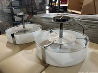 Two small round chrome/white pendant lights showing diffusers and mounting plates