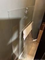 Stack of clear acrylic panels leaning against wall