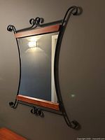 Full view of wall mirror showing metal frame and wood accents