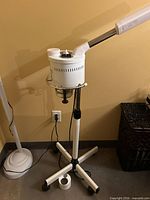 Full view of HR facial steamer on adjustable stand with caster base and power cord