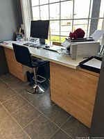 Full view of desk with white top, dual file cabinets, monitor and accessories on surface