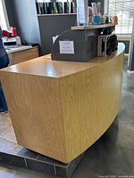 Front three-quarter view showing curved light oak veneer front and side panel