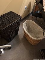 Dark brown rectangular wicker hamper next to natural wicker oval basket showing liners