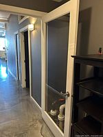 Door shown open, painted wood frame, clear glass pane, lever handle visible