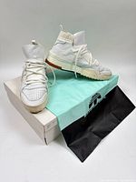 Sneakers displayed on box with dust bag visible