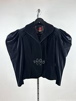 Front view of black Anne Klein jacket on hanger showing overall style