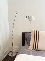 Full view of Tolomeo floor lamp beside bed