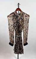 Front view of leopard print silk dress on hanger with silver belt