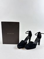 Shoes standing beside original Gucci box
