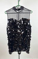 Front view of black sequined mesh dress on hanger