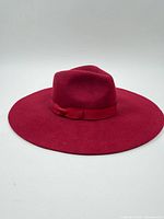 Top view of red wool fedora showing full wide brim and crown with ribbon band