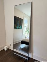 Full view of mirror standing against wall